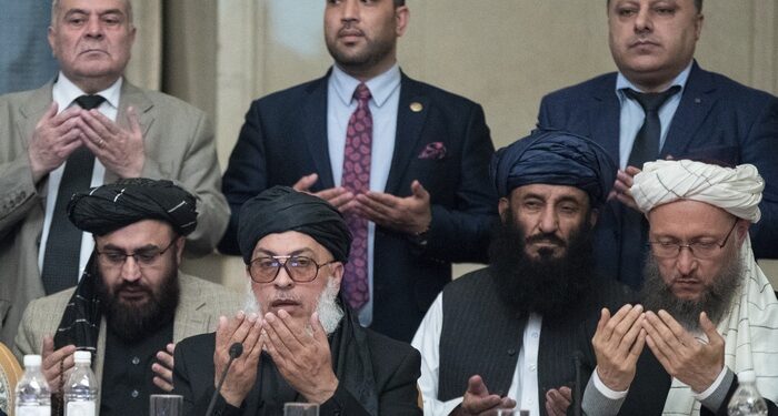 Taliban political chief Sher Mohammad Abbas Stanikzai, first row second from left, Abdul Salam Hanafi and other Taliban official pray during the "intra-Afghan" talks in Moscow, Russia, Wednesday, Feb. 6, 2019. The U.S. has promised to withdraw half of its troops from Afghanistan by the end of April, a Taliban official said Wednesday, but the U.S. military said it has received no orders to begin packing up. (AP Photo/Pavel Golovkin)