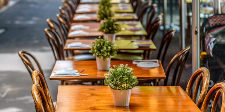 A row of chairs and tables at a outdoor cafe on Lygon Street, Carlton, Melbourne, Australia