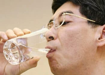 Japan's Parliamentary Secretary for the Cabinet Office Yasuhiro Sonoda drinks a glass of decontaminated water taken from puddles inside the buildings housing reactors 5 and 6 at the Fukushima No. 1 plant.